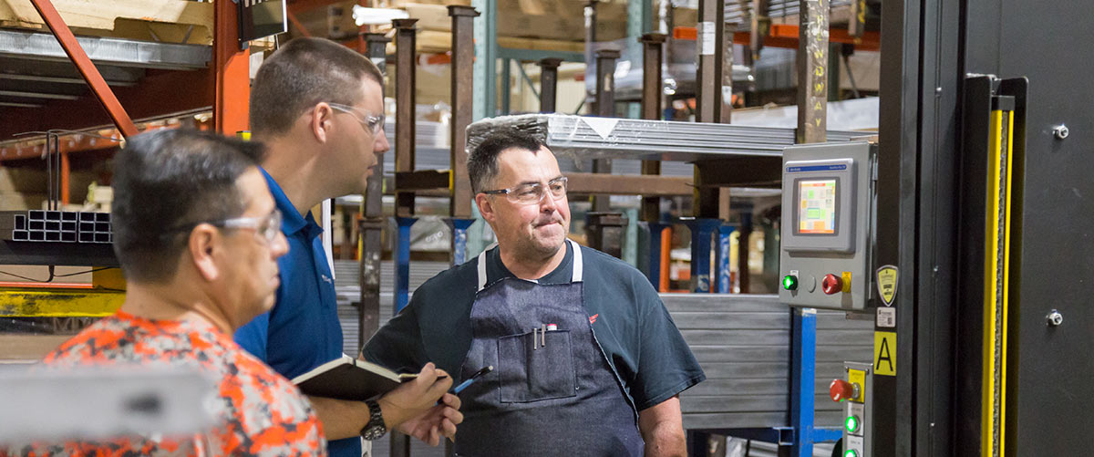 Engineer talking with workers in manufacturing space