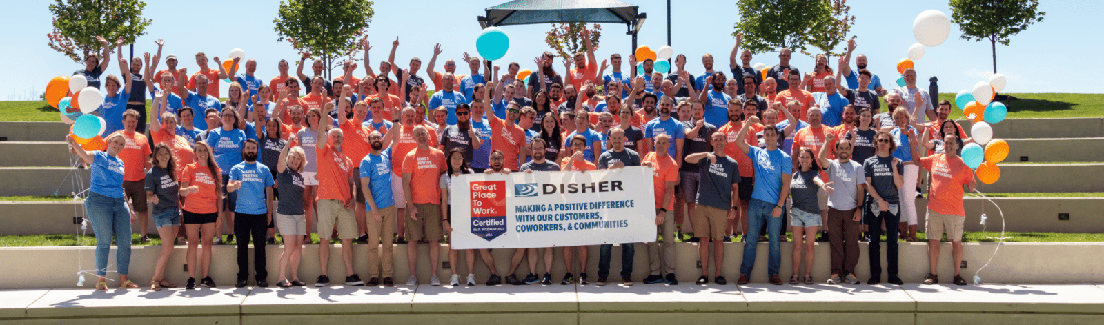 The greater DISHER team posing with a great places to work banner. 