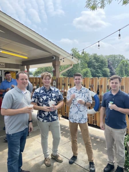 Four male DISHER employees smiling with ice cream