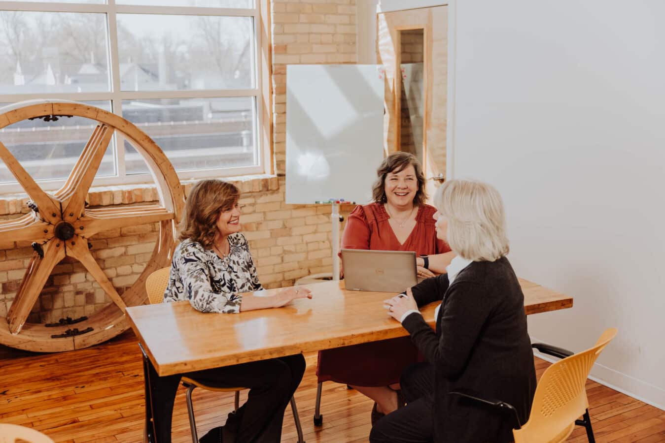 Two recruiters sit at a table discussing a customer project