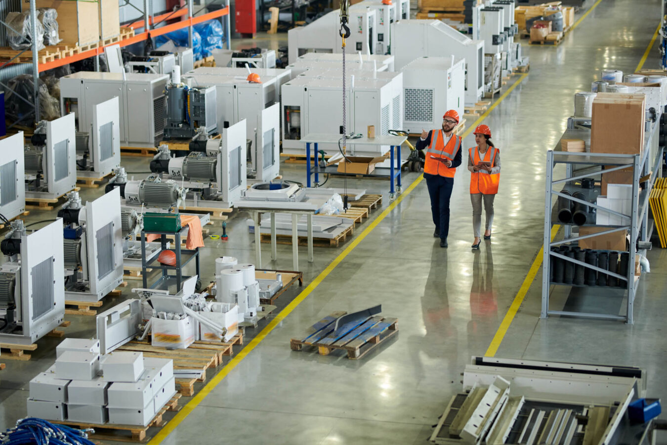 Man and woman walking through a manufacturing plant